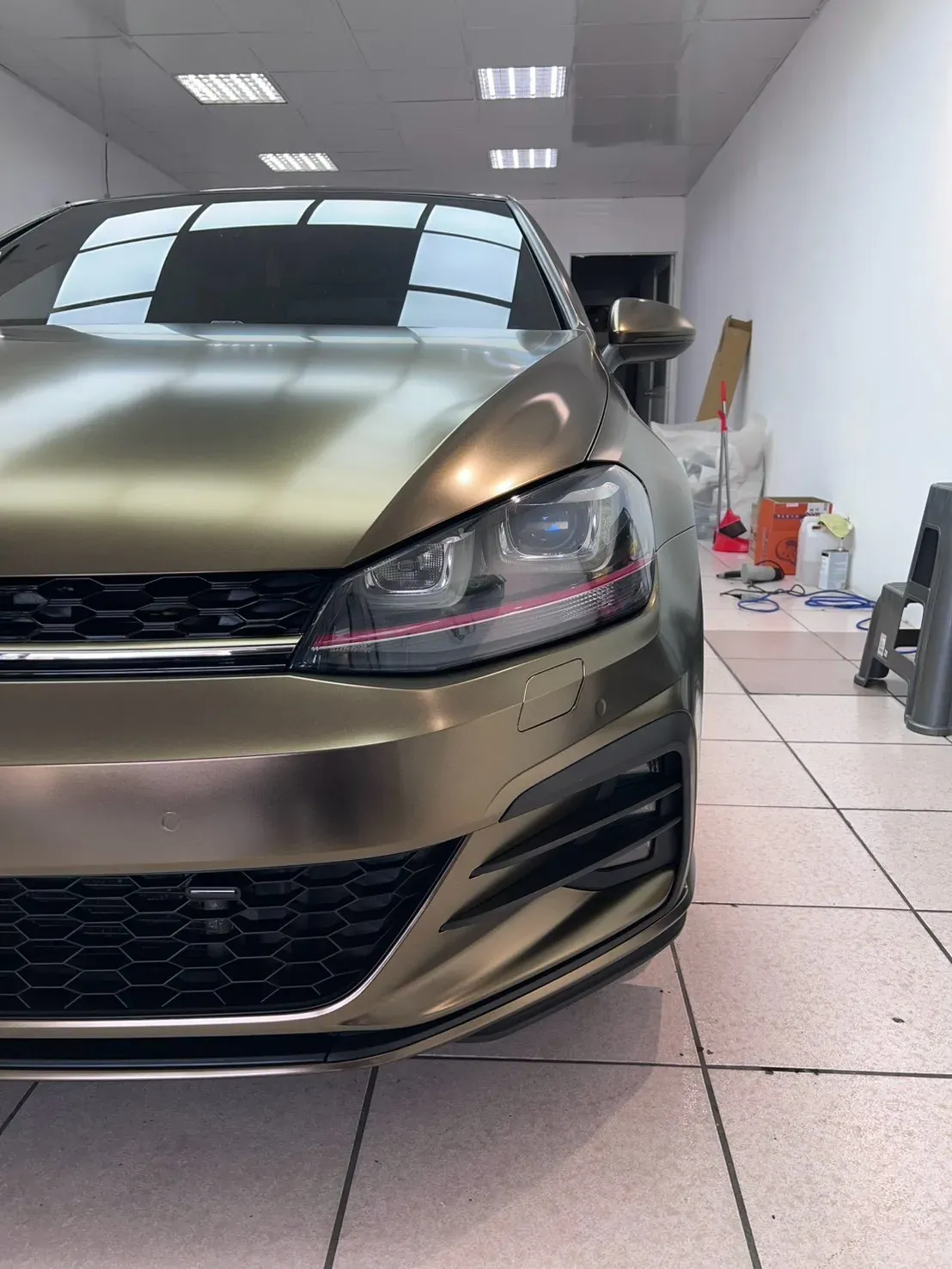 Volkswagen Golf GTI 暮光金車頭斜前，頭燈與紅色飾條一帶
